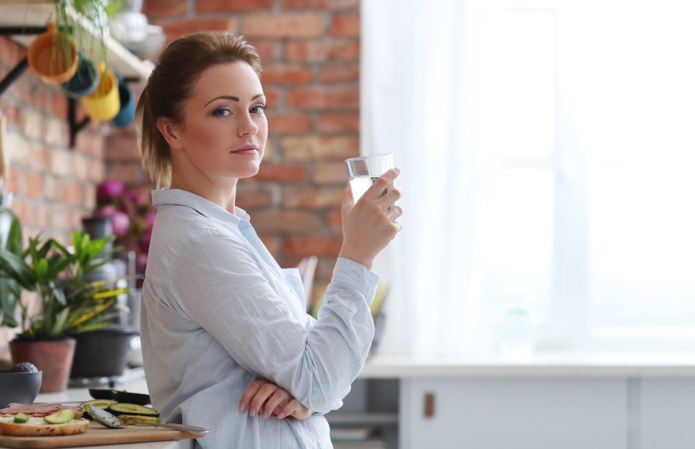 Person drinking water as part of quick weight loss tips