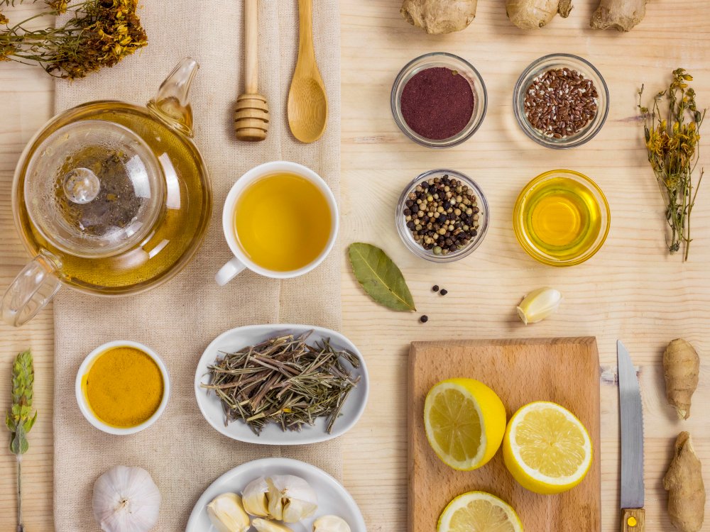 Bowls of honey, turmeric, fenugreek leaves, and lemon arranged for blackheads remedies